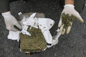 Un policía colombiano revisa un paquete con marihuana confiscada en Cali, feb 14 2014